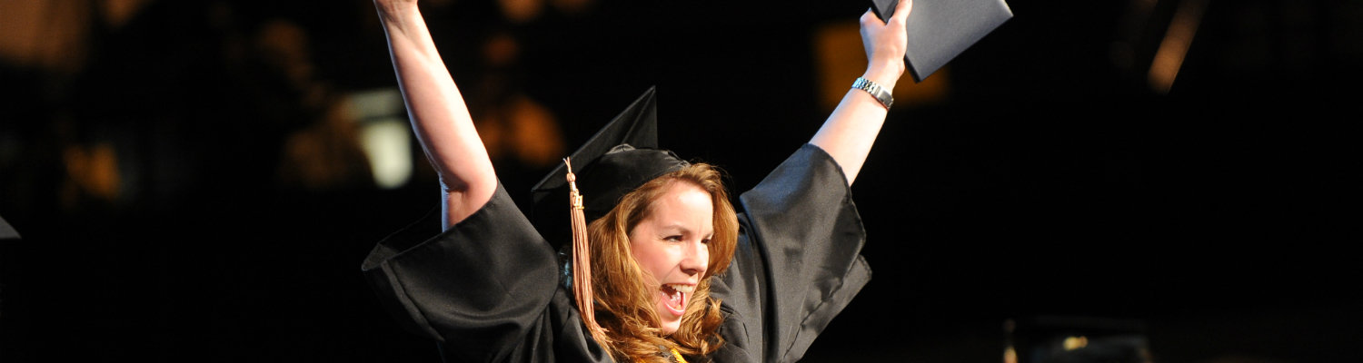 A graduate of Kent State is all smiles during her commencement ceremony.